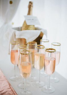 five champagne flutes are lined up on a table