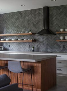 a kitchen with an island and shelves filled with dishes on top of it's counter tops