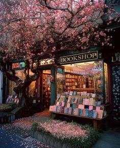 a tree with pink flowers in front of a bookstore