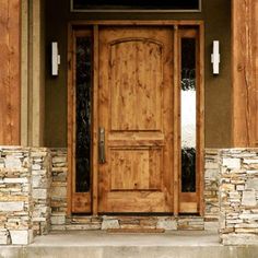 a large wooden door sitting on the side of a building next to a stone wall