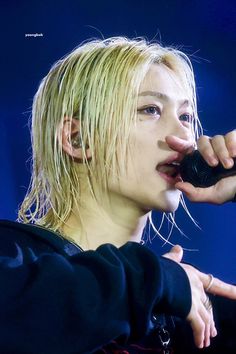 a person holding a microphone up to their face with one hand and the other in front of her