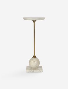 a white marble table with a gold metal base and an apple on it's side