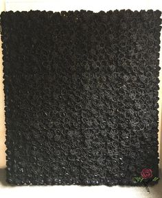 a wall made out of black mesh with a rose on the bottom and one flower in the middle