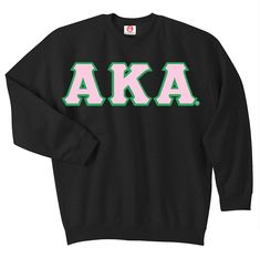 a black sweatshirt with the letters aka in green and pink, on a white background