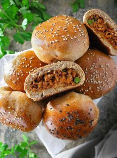 several buns stacked on top of each other with meat in the middle and sprinkled seeds