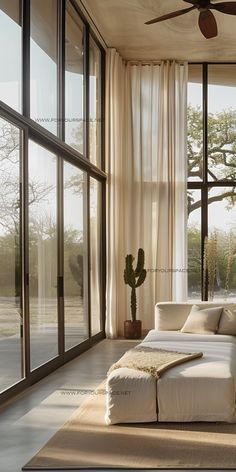 a living room with large windows and a white couch