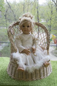 a doll sitting in a wicker chair