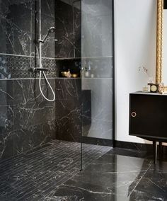 a walk in shower sitting next to a black cabinet