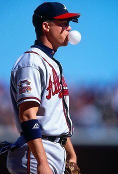 a baseball player holding a ball in his mouth