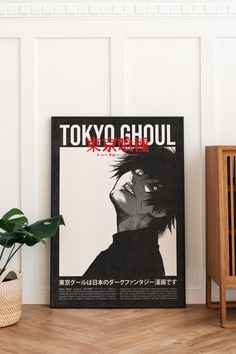 a poster with the words tokyo ghoul on it next to a potted plant