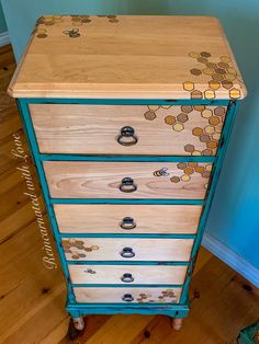 an old dresser has been painted with honeycombs on it and is sitting against a blue wall