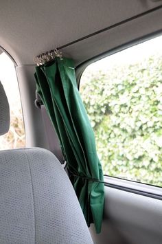 the inside of a car with a green curtain hanging from it's side window