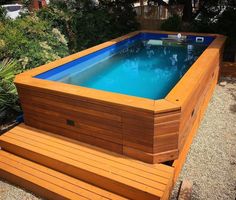 an above ground swimming pool with steps leading up to it and a wooden deck in the foreground