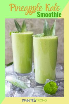 two glasses filled with green smoothie sitting on top of an ice - covered table