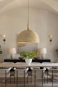 a dining room table with chairs and a vase on the table in front of it