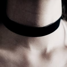 a woman wearing a black choker with no shirt on