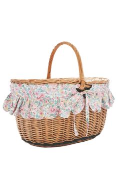 a wicker basket with flowers on the side and ruffled trimmings,