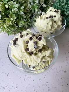 two glass bowls filled with ice cream and chocolate chips on top of a white table