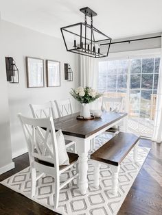 a dining room table with white chairs and wooden benches