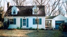 a white house with blue shutters and trees