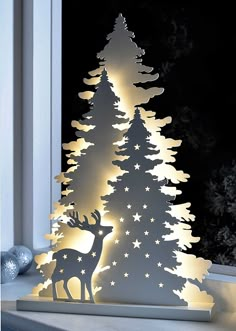 a paper cut out of a christmas tree with stars on it and a deer standing next to it