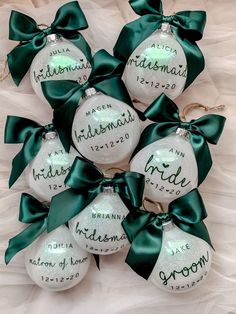 six green and white ornaments with names on them