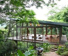 a house in the middle of trees with stairs leading up to it's roof