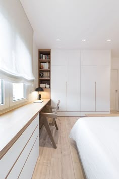 a bedroom with white walls and wooden floors