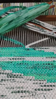 some green and white items are laying out on the weaving loom with it's needles