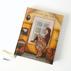 a book with an image of a woman sitting on a window sill