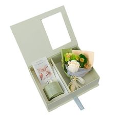 an open box with flowers and other items in it