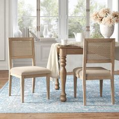 a dining room table with chairs and a rug