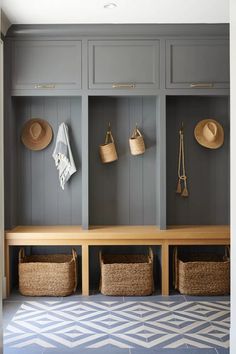 an entryway with gray cabinets and baskets