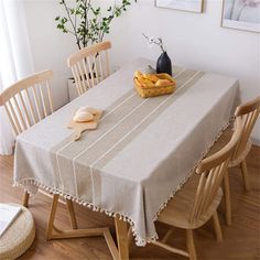 a dining room table covered with a linen tablecloth and some bread on top of it