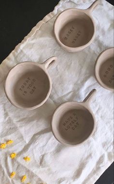 three ceramic measuring spoons sitting on top of a white towel next to corn kernel