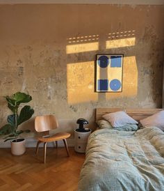 a bedroom with a bed, two chairs and a painting on the wall