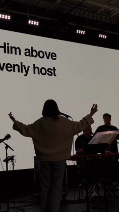 a person standing in front of a large screen with his arms spread out to the side