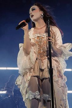 a woman in white dress holding a microphone