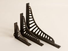 two black metal brackets sitting on top of each other