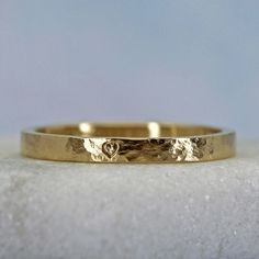 This personalized gold stacking ring has a rustic distressed finish that gives it a gentle timeworn vibe. The distressed finish gives the ring a subtle shine. Your inscription can go on the outside or the inside of this sweet little ring. Details Made from solid 14k yellow gold. 2mm wide and about 1.2mm thick. Rustic hammered finish Price includes an inscription of up to 14 characters.Available are uppercase letters A-Z, numbers 0-9, &, . , -, and a little heart symbol Important! The ring will b Gold Hammered Stackable Rings For Promise, 14k Gold Hammered Stackable Promise Rings, Hammered 14k Gold Stackable Wedding Rings, 14k Gold Hammered Stackable Wedding Rings, Dainty Hammered Stackable Wedding Rings, Gold Hammered Stackable Rings For Anniversary, Hammered Stackable Round Band Rings As Gifts, Anniversary Yellow Gold Hammered Stackable Rings, Rustic Hand Forged Rings For Anniversary