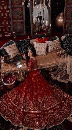 a woman in a red dress sitting on a couch