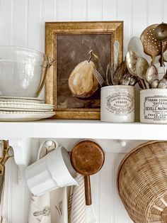 a shelf filled with kitchen utensils and other items on top of a white wall