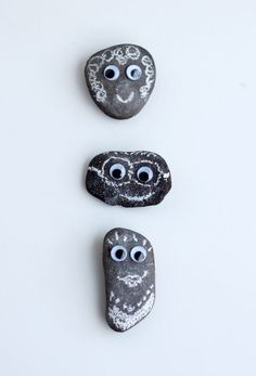 three rocks with eyes painted on them