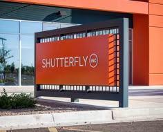 a sign that says shutterfly on it in front of a building with large windows