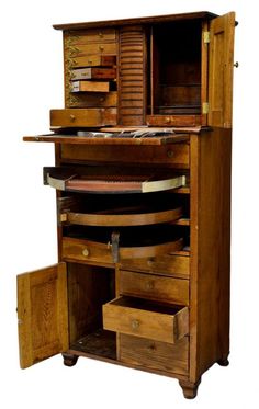 an old fashioned wooden desk with drawers on the top and bottom drawer open to show what's inside