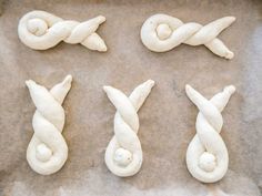 four different types of dough that are on a baking sheet, one is knoted and the other is uncooked