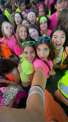 a group of young people standing next to each other wearing neon colored shirts and sunglasses