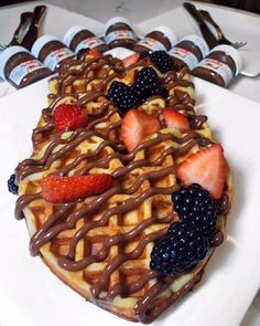 a waffle topped with chocolate syrup and fruit