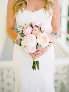 a bride holding a bouquet of pink and white flowers