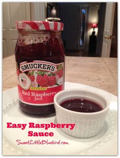 a jar of raspberry sauce sitting on top of a white plate